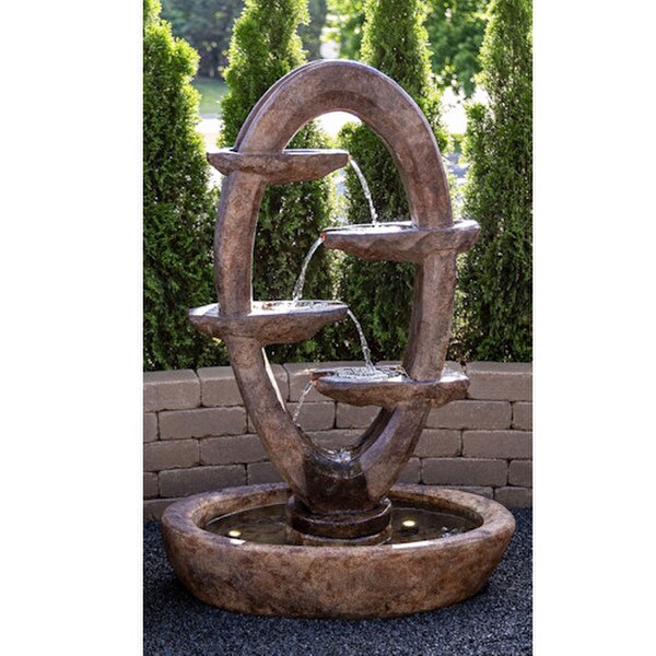 Ellipse fountain flowing back and forth between intricately carved stone scuppers